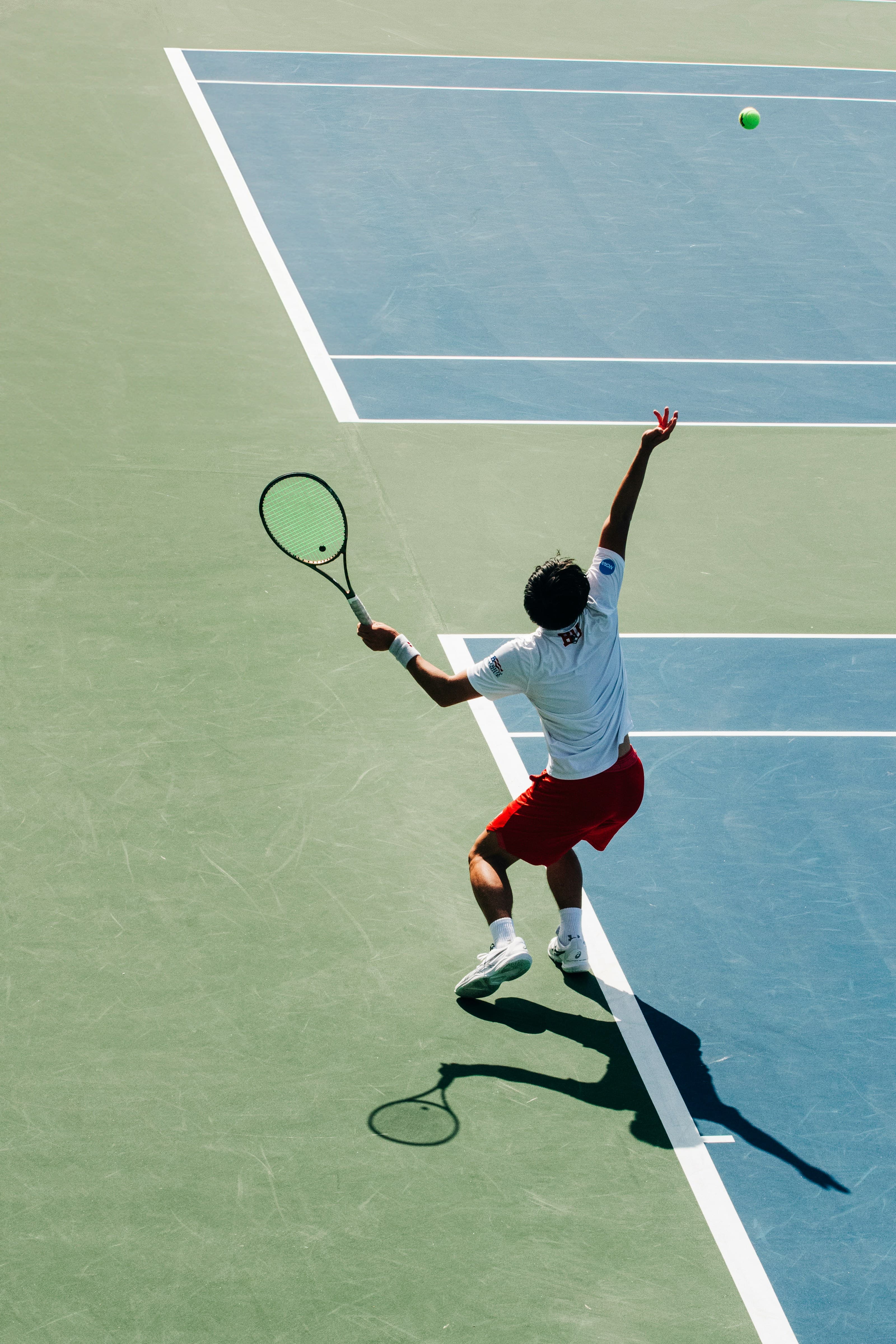 A tennis player serving on court